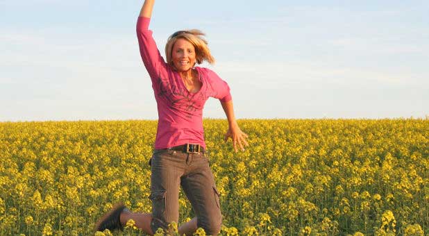 woman jumping in field of flowers