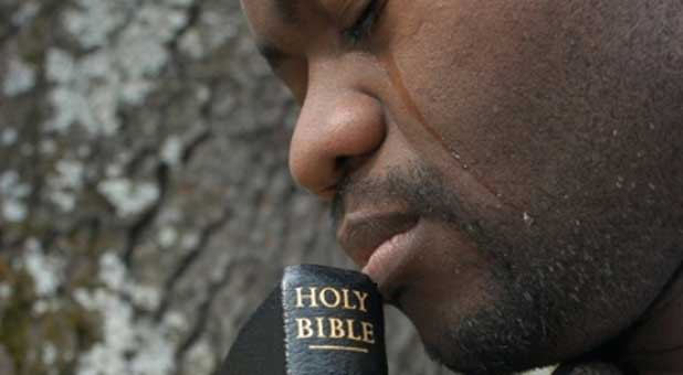 man in tears with Bible