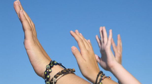 girls with hands raised to the sky