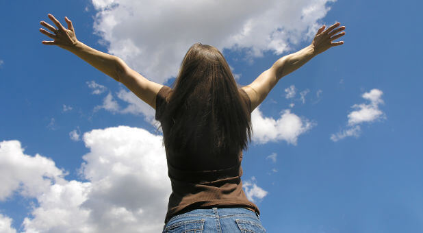 woman hands raised to the sky